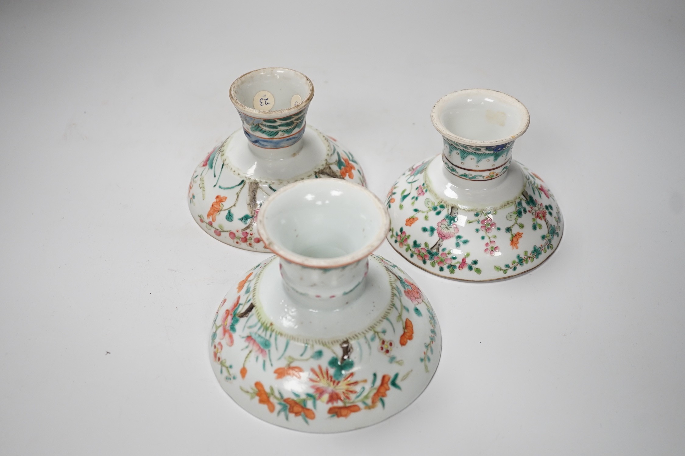 Three 19th century Chinese famille rose pedestal stem bowls, each painted with flowers and foliage, 9.5cm tall